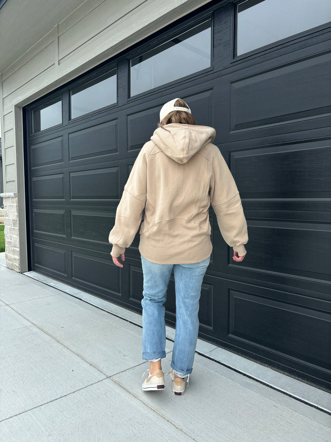 back view of Carter half-zip hoodie in oat color with pocket and thumbholes, 50/50 cotton/poly blend, shown in size medium