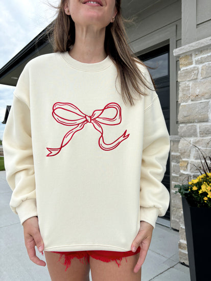 graphic detail of Carlton cream and crimson bow sweater, 100% polyester, shown in size medium