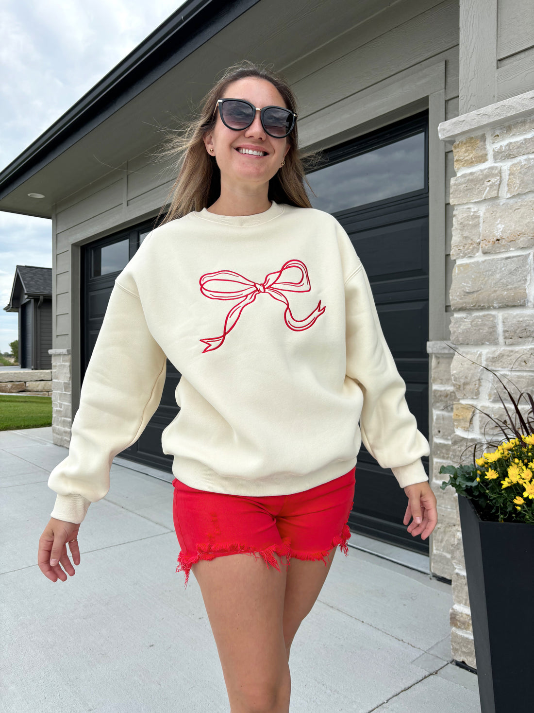 styled view of Carlton cream and crimson bow sweater, 100% polyester, shown in size medium