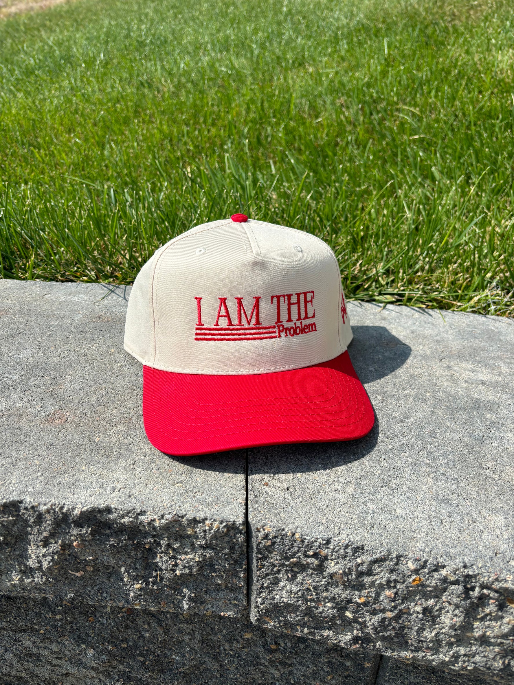 Red and natural women's trucker hat with 'I Am The Problem' statement design